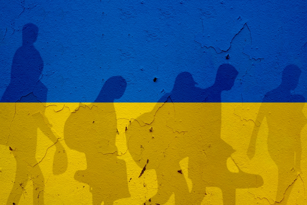 Ukraine flag on wall and refugee shadows