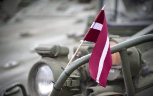 Latvian flag and military Vehicle