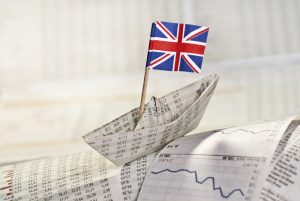 Paper ship with British flag on stock market news