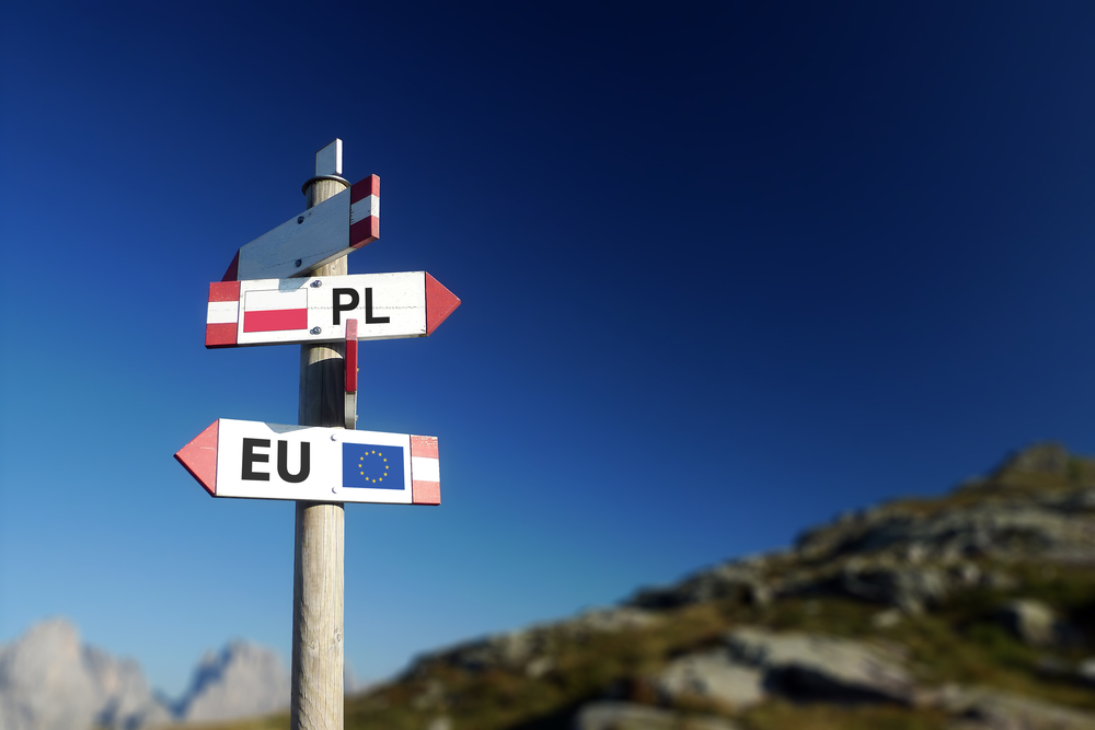 Poland and EU flags in two directions on the road