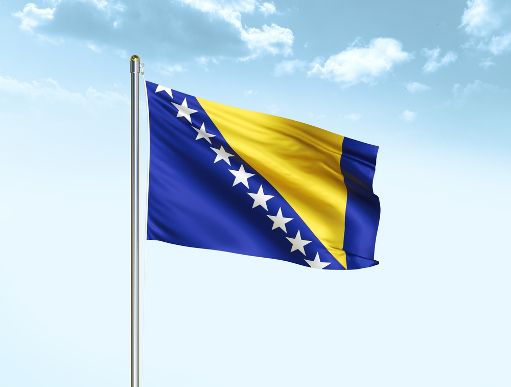 Bosnia,And,Herzegovina,Flag,Waving,On,Blue,Sky,Background