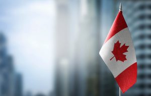A,Small,Flag,Of,Canada,On,The,Background,Of,A, city