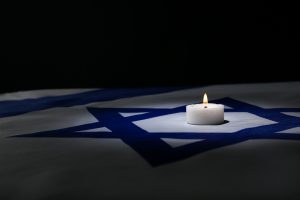 Burning,Candle,On,Flag,Of,Israel,Against,Dark,Background